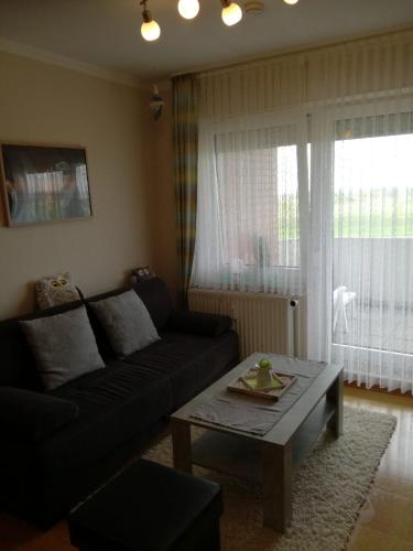 a living room with a couch and a coffee table at FeWo Schwarz in Dornumersiel
