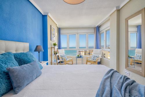 a blue bedroom with a bed and a view of the ocean at SPECTACULAR VIEWS PENTHOUSE IN 1ST LINE BEACH in Torrox Costa