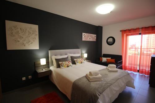una camera da letto con un letto e due asciugamani di T1 Praia da Rocha/ Paraíso Sol da Rocha 3 a Portimão