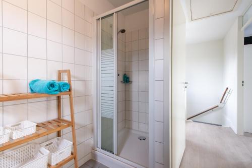 eine Dusche in einem Badezimmer mit weiß gefliesten Wänden in der Unterkunft Maxime 207 - Kustpark Village Scaldia in Hoofdplaat