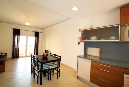 a kitchen with a table and chairs in a room at T1 Praia da Rocha/1ª linha in Portimão