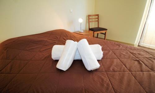 a bed with white towels on top of it at T1 Praia da Rocha/1ª linha in Portimão