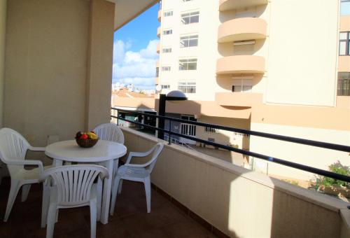 a balcony with a table and chairs and a window at T1 Praia da Rocha/1ª linha in Portimão