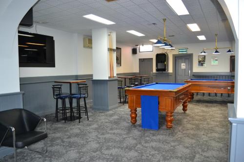 a kitchen with a table, chairs and a refrigerator at Colac Central Hotel-Motel in Colac
