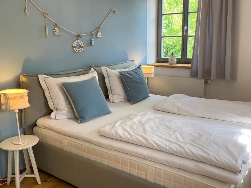 1 dormitorio con cama con almohadas y ventana en Landgut Mosch en Radeburg