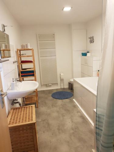 a bathroom with a sink and a tub and a toilet at Ferienwohnung Schwabendorf - nahe Marburg in Rauschenberg