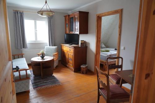 een woonkamer met een tafel en een spiegel bij Pension Mitteltorturm in Prenzlau