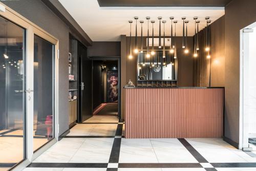 a lobby with a red counter and a chandelier at City Solei Boutique Hotel in Poznań