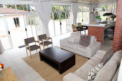 a living room with a couch and chairs and a table at Elegant Lodge & Conference Center in Pongola