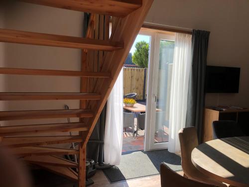 a staircase leading to a room with a sliding glass door at Slaperij Salud! Studios & appartementen in Scharendijke