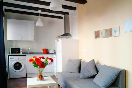 una sala de estar con sofá y un jarrón de flores en Down Town, en Valencia