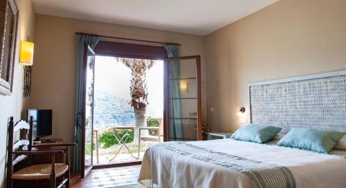 
a large bed in a bedroom next to a window at Hotel Cortijo de Salia in Alcaucín
