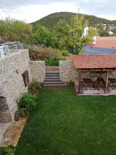 a backyard with a picnic table and a stone wall at Arácsi Vendégház in Balatonfüred