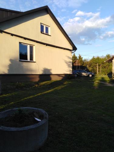 un patio con una casa y un coche en el fondo en noclegi kwatery, en Wola Rębkowska