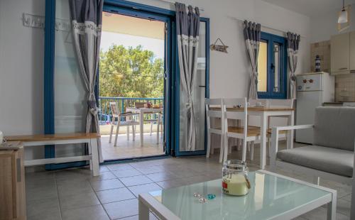 a kitchen and living room with a view of a patio at MMM Apartment in Makry Gialos