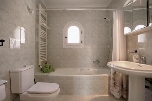 ein Badezimmer mit Badewanne, Toilette und Waschbecken in der Unterkunft Casa León with private pool great view in Benissa