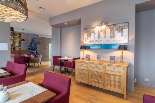 a dining room with purple chairs and a christmas tree at Hotel Nawigator Szczawnica in Szczawnica