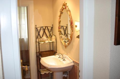 a bathroom with a sink and a mirror at Hotel Arcea Palacio de las Nieves in Langreo