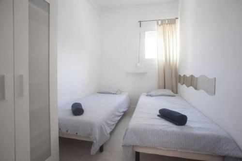 2 łóżka w pokoju z białymi ścianami w obiekcie Bonito Apartamento Sol Tarifa, centrico y cerca de la playa w mieście Tarifa