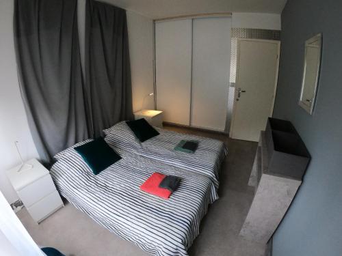 - une chambre avec un lit et un livre rouge dans l'établissement PASSERELLE DU MARIN, à Ajaccio