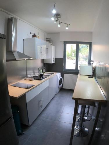 une cuisine avec des armoires blanches et un comptoir dans l'établissement PASSERELLE DU MARIN, à Ajaccio