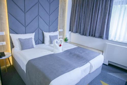 Pokój hotelowy z dużym łóżkiem z ozdobą łabędzia w obiekcie Hotel Boutique Bristol w Sarajewie