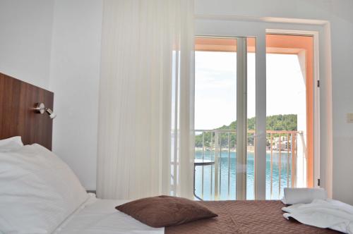 a bedroom with a bed with a view of the ocean at Villa Stina Drvenik in Drvenik