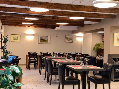 - une salle à manger avec des tables et des chaises dans l'établissement Auberge du Cezallier, à Montgreleix