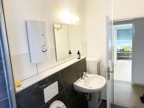 a white bathroom with a sink and a mirror at My-Skypalace Bad-Friedrichshall in Bad Friedrichshall