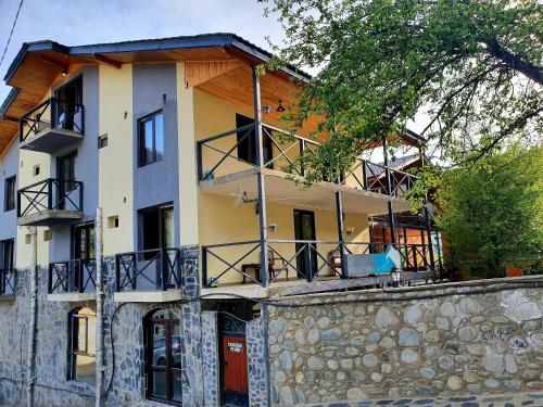 a large building with balconies on top of a stone wall at Nino Ratiani's Guesthouse in Mestia