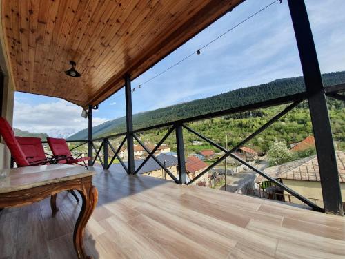 a room with two chairs on a balcony with large windows at Nino Ratiani's Guesthouse in Mestia