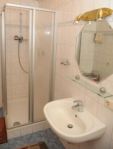 a white bathroom with a shower and a sink at Woferlhof, Ferienhof Boxhorn in Böbrach