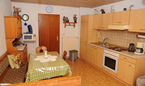 a kitchen with a table and a kitchen with a sink at Woferlhof, Ferienhof Boxhorn in Böbrach