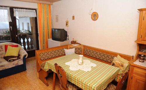 a small living room with a table and a tv at Woferlhof, Ferienhof Boxhorn in Böbrach