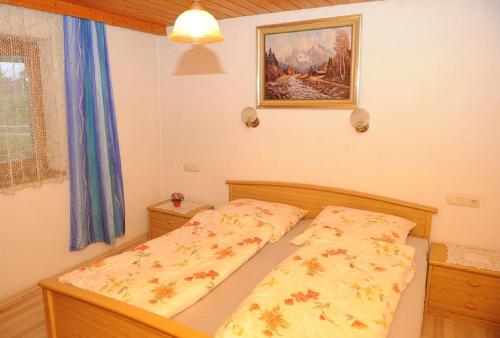 a small bedroom with a bed with a yellow comforter at Woferlhof, Ferienhof Boxhorn in Böbrach