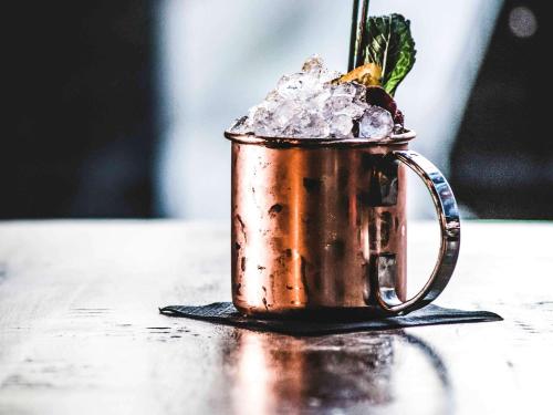 a copper cup with a drink in it on a table at Novotel Leeds Centre in Leeds