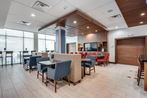 a dining room with tables and chairs in a building at Holiday Inn Express & Suites Dallas North - Addison by IHG in Addison