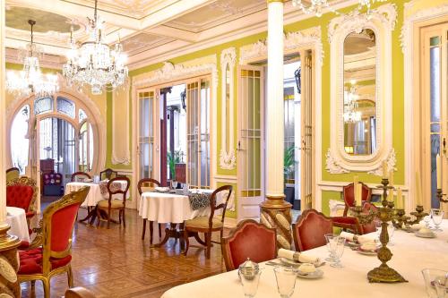 a restaurant with tables and chairs and a chandelier at Palacete Chafariz Del Rei - by Unlock Hotels in Lisbon