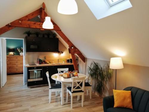 a living room with a table and a kitchen at Le petit Mérinos - Rambouillet - in Rambouillet