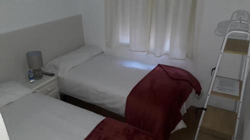 Łóżko lub łóżka w pokoju w obiekcie Hostal VILLA CARBULA