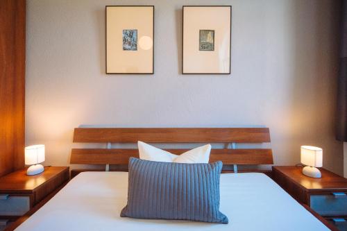a bedroom with a bed with two lights on the wall at Apartmenthaus Kaiser Friedrich in Potsdam