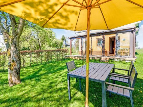 uma mesa de piquenique com um guarda-chuva amarelo num quintal em Amazing Holiday Home in Porcheresse Daverdisse with Terrace em Porcheresse