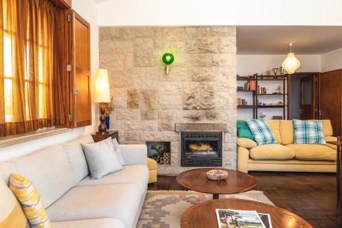 a living room with a couch and a fireplace at Vivenda MiraSerra in Santana