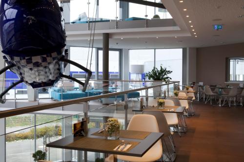 a restaurant with tables and chairs and windows at Aircraft Hotel & Events in Neuhausen ob Eck