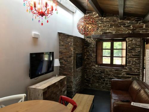 a living room with a tv and a table at Casas Rurales TAReira en Taramundi in Taramundi