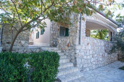 a stone house with a stone wall at House Dino in Tkon