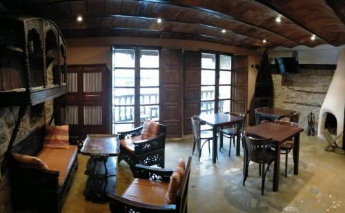 a dining room with tables and chairs and windows at Las Casas de Isu in Villaviciosa