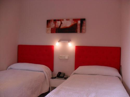 two beds in a room with red headboards at Hotel Lo Monte in Pilar de la Horadada