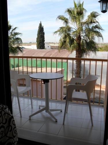 a balcony with a table and chairs and a palm tree at Hotel Lo Monte in Pilar de la Horadada