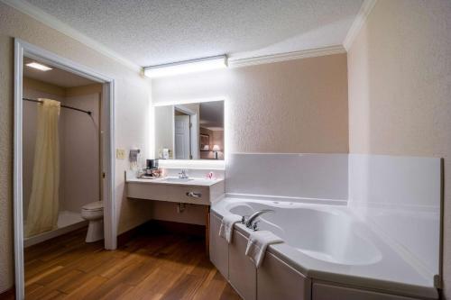 a bathroom with a tub and a sink and a toilet at Econo Lodge Inn & Suites Cayce in Cayce